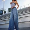 Blugi largi, cu talie joasă, spălați închis la culoare, brodați cu inscripția „Class of ’26” Blugi largi, cu talie joasă, spălați închis la culoare, brodați cu inscripția „Class of ’26”