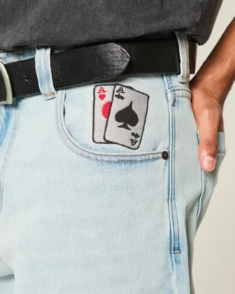 Blugi largi, de culoare deschisă, cu imprimeu de cărți de joc