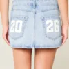 Fustă-pantalon mini din denim cu talie joasă, modelul „Class of ’26” Fustă-pantalon mini din denim cu talie joasă, modelul „Class of ’26”