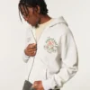 Hanorac cu glugă și imprimeu grafic Boxy Zip-Up University of Miami Hurricanes Hanorac cu glugă și imprimeu grafic Boxy Zip-Up University of Miami Hurricanes