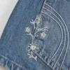 Mini pantaloni scurți din denim cu talie ultra joasă, spălare medie și broderie florală Mini pantaloni scurți din denim cu talie ultra joasă, spălare medie și broderie florală