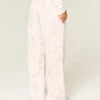 Pantaloni de trening largi cu logo grafic roz camuflaj Pantaloni de trening largi cu logo grafic roz camuflaj