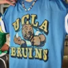 Universitatea din California, Los Angeles, tricou de fotbal cu grafică Bruins Universitatea din California, Los Angeles, tricou de fotbal cu grafică Bruins